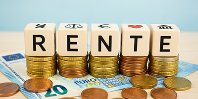 5 Würfel mit Buchstaben, die das Wort Rente ergeben. liegen auf kleinen Spapeln mit Kleingeld, dies alles liegt auf einem 20 Euro Schein.