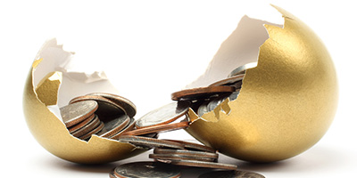 Coins came out from a cracked open gold egg. Isolated on white background.