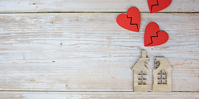 Divorce, division of property, poverty and no money concept. Wooden house with broken heart and house on wooden background. Mortgage, rent, Real Estate Agent top view copy space space for text