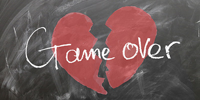 Kreidetafel, auf die ein zerbrochenes Herz gemalt ist, darüber der Schriftzug 'Game over'