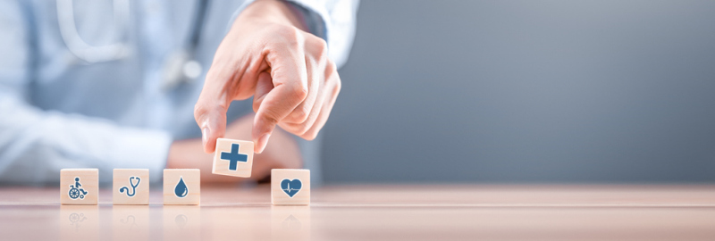 Handanordnung des Holzblocks mit medizinischem Symbol für das Gesundheitswesen. Krankenversicherung - Konzept.
