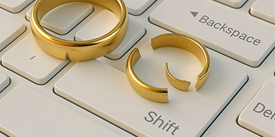 zerbrochene Eheringe auf einer Tastatur