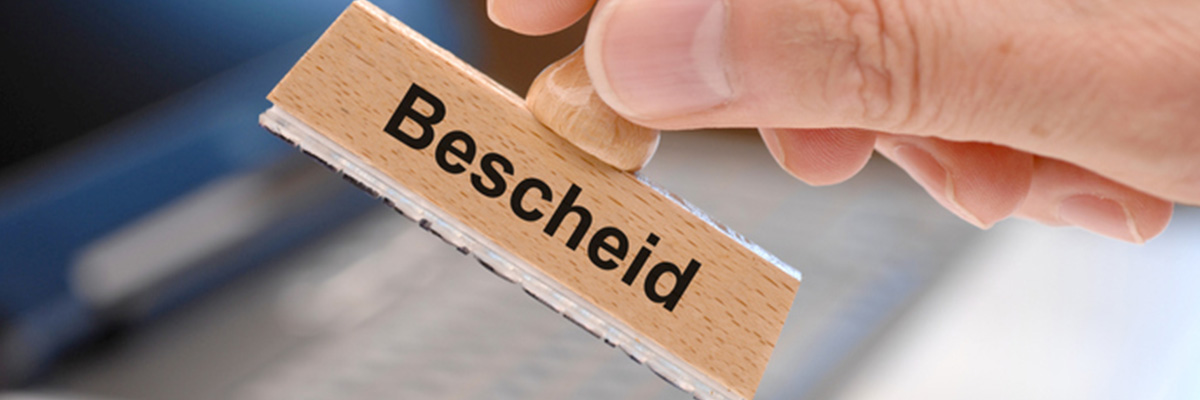 Bescheid - Stempel auf einem Blatt Papier
